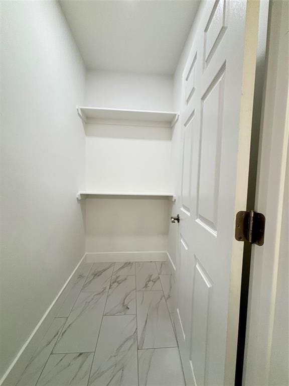 spacious closet featuring marble finish floor