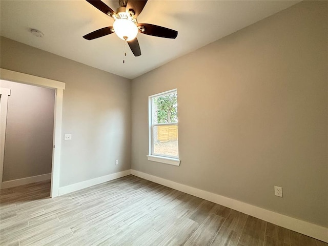 empty room featuring baseboards, light wood-type flooring, and ceiling fan