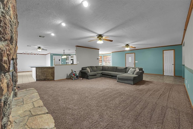 living room featuring visible vents, crown molding, ceiling fan, carpet, and a textured ceiling