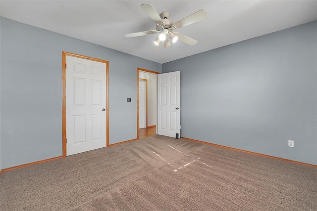 unfurnished bedroom featuring carpet, baseboards, and ceiling fan