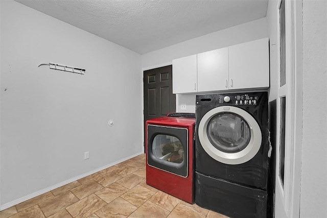 laundry room with washer and clothes dryer, cabinet space, a textured ceiling, and baseboards