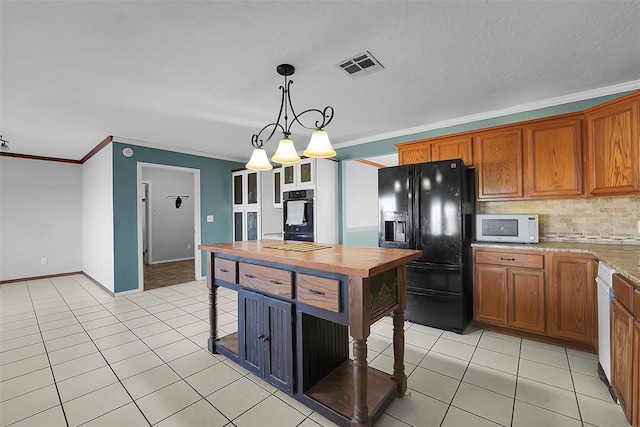 kitchen featuring light tile patterned floors, visible vents, ornamental molding, black appliances, and brown cabinets