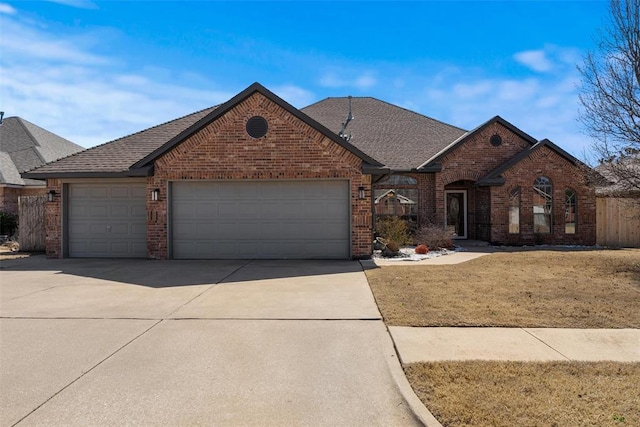 view of front of home with fence, concrete driveway, a front lawn, a garage, and brick siding