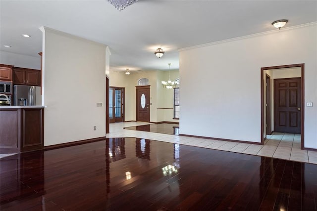 unfurnished living room with ornamental molding, recessed lighting, light wood-style floors, baseboards, and a chandelier