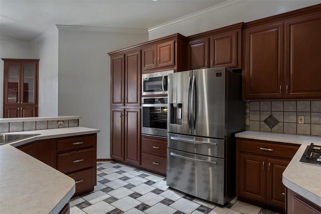 kitchen with tasteful backsplash, crown molding, light floors, light countertops, and stainless steel appliances