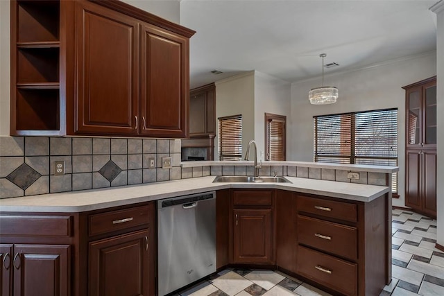 kitchen with visible vents, light countertops, a peninsula, stainless steel dishwasher, and a sink