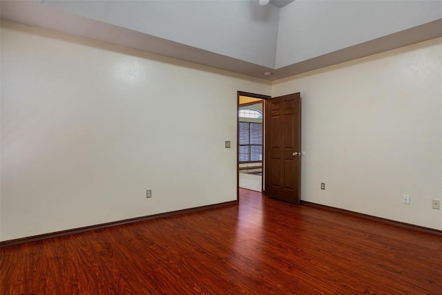 unfurnished room featuring a high ceiling, wood finished floors, and baseboards