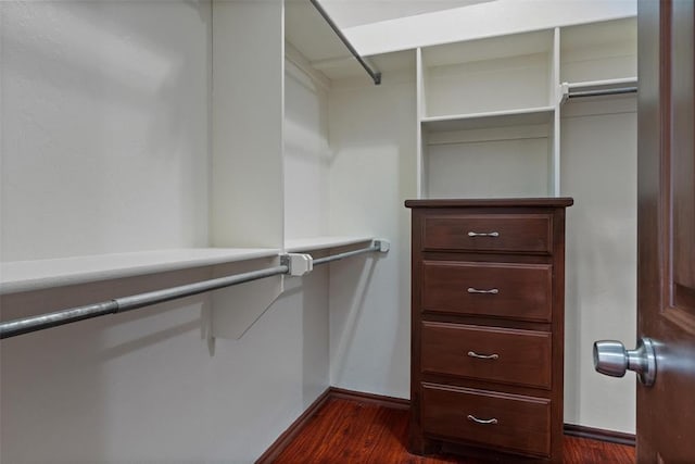 walk in closet with dark wood-type flooring