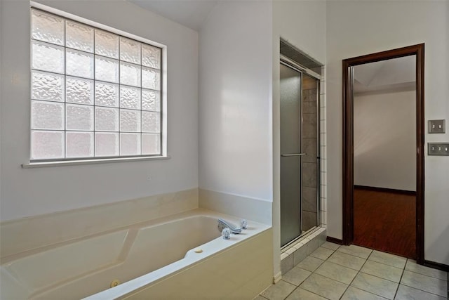 full bathroom featuring a shower stall, a garden tub, and tile patterned floors