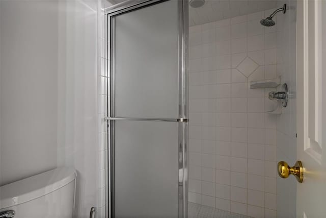 bathroom featuring a stall shower and toilet