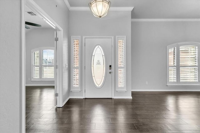 foyer featuring crown molding, baseboards, dark wood-style flooring, and visible vents