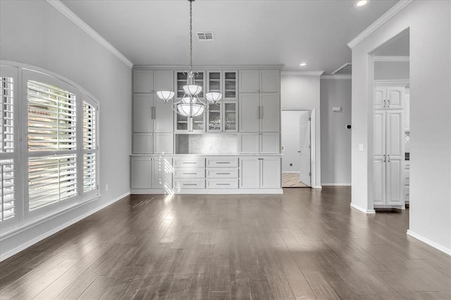 unfurnished dining area featuring visible vents, baseboards, a notable chandelier, and dark wood-style floors