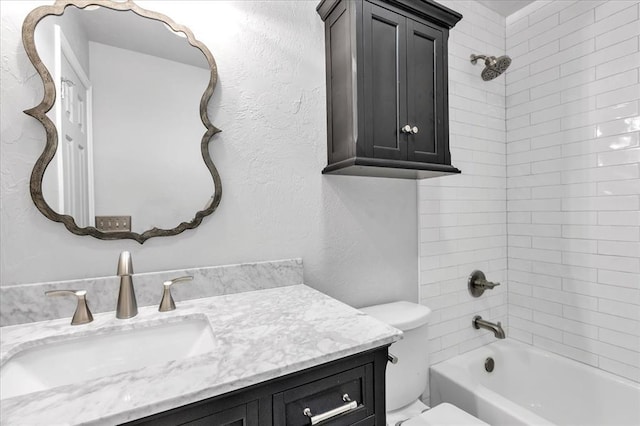 full bath featuring vanity, shower / bathing tub combination, toilet, and a textured wall