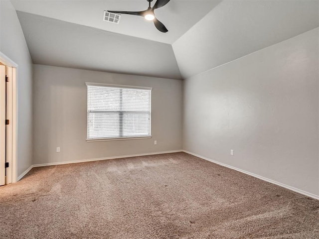 spare room with visible vents, carpet, baseboards, ceiling fan, and vaulted ceiling