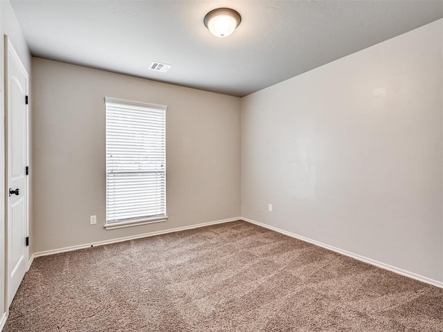 carpeted empty room with visible vents and baseboards