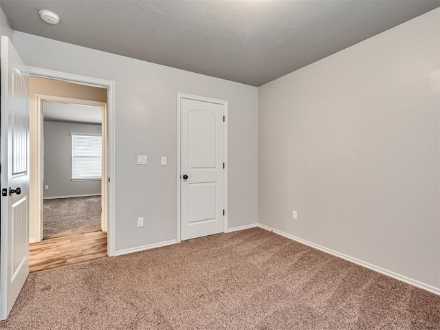 unfurnished room featuring carpet flooring and baseboards