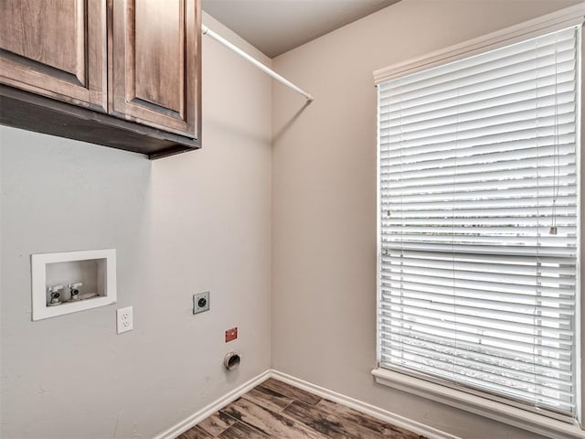 clothes washing area featuring electric dryer hookup, wood finished floors, cabinet space, baseboards, and hookup for a washing machine