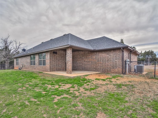 rear view of house with a yard, fence, brick siding, and a patio area