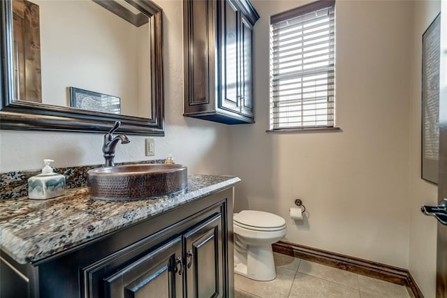 bathroom featuring tile patterned floors, baseboards, toilet, and vanity