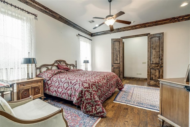 bedroom with visible vents, crown molding, a ceiling fan, and wood finished floors