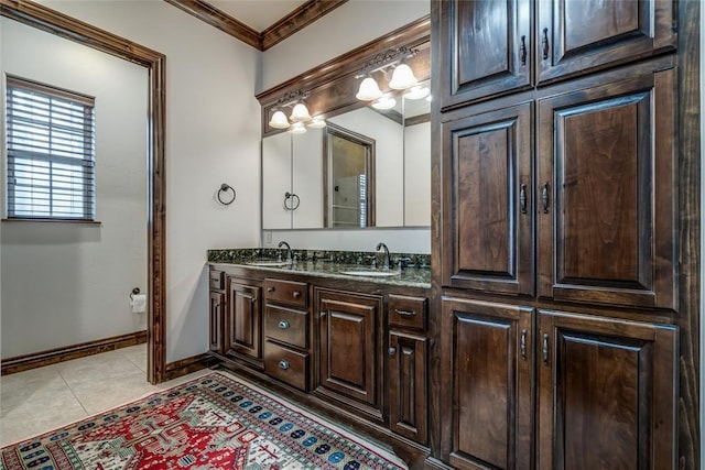 full bathroom featuring tile patterned flooring, crown molding, baseboards, and a sink