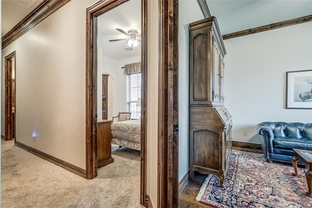 hallway with carpet, arched walkways, and baseboards