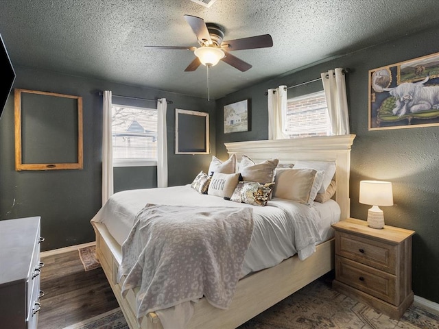 bedroom with dark wood-style floors, multiple windows, and a textured ceiling