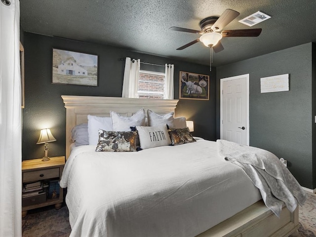 bedroom featuring visible vents, a textured ceiling, a ceiling fan, and a textured wall