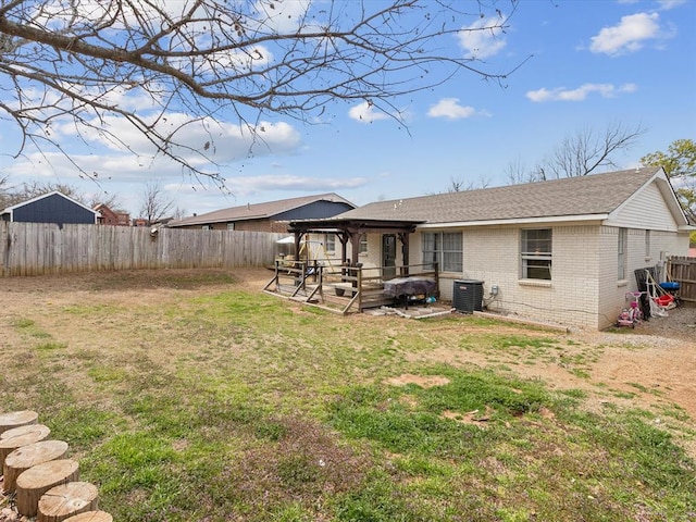 back of house featuring brick siding, central air condition unit, a gazebo, a yard, and a fenced backyard