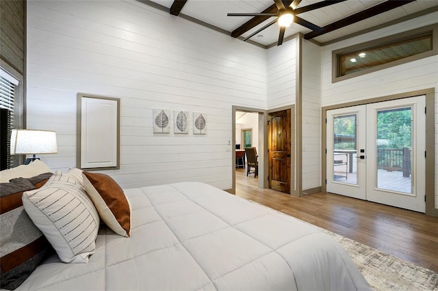 bedroom featuring beamed ceiling, french doors, wood finished floors, and access to outside