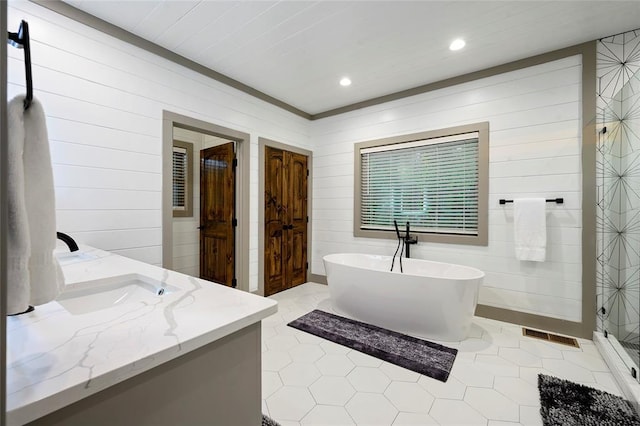 bathroom featuring vanity, visible vents, a freestanding tub, recessed lighting, and tile patterned flooring