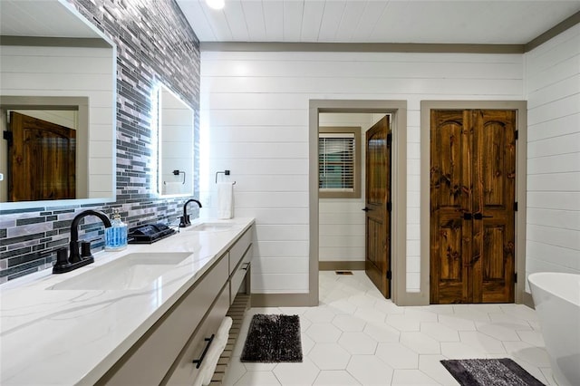 full bathroom featuring a sink, tasteful backsplash, double vanity, and tile patterned floors