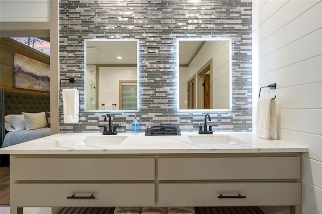 bathroom featuring double vanity, backsplash, and a sink