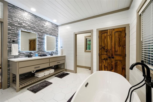 bathroom featuring wood ceiling, double vanity, tile patterned floors, a soaking tub, and a sink