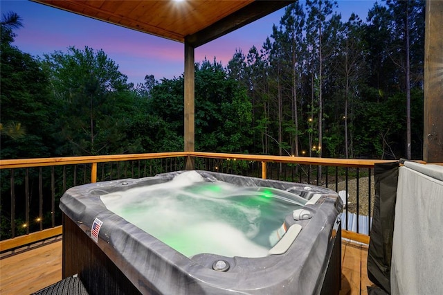 deck at dusk with a hot tub