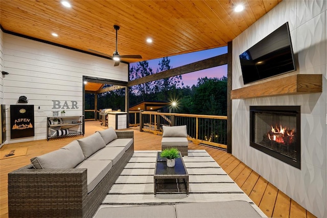 wooden terrace with an outdoor living space with a fireplace