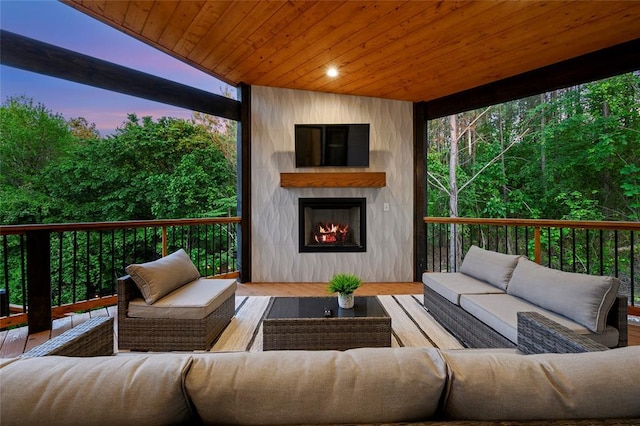 wooden terrace featuring an outdoor living space with a fireplace