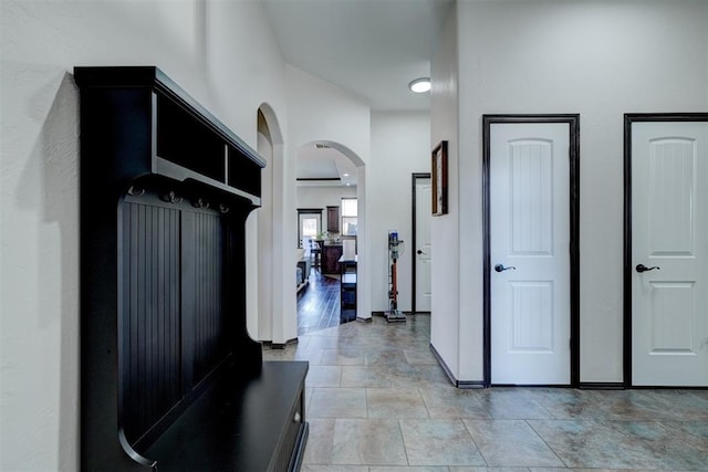 hallway featuring baseboards and arched walkways