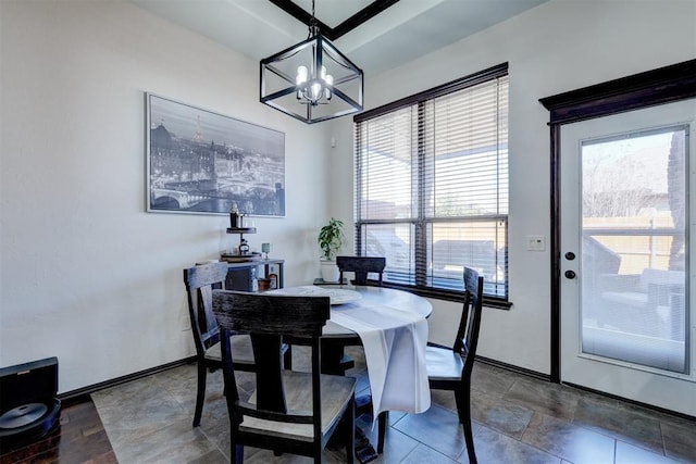 dining space with baseboards and a chandelier