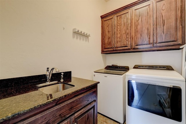 washroom with cabinet space, separate washer and dryer, and a sink