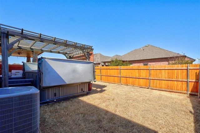 view of yard with central air condition unit, a fenced backyard, and a pergola