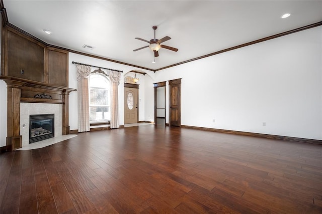 unfurnished living room featuring baseboards, visible vents, a fireplace, ceiling fan, and dark wood-type flooring