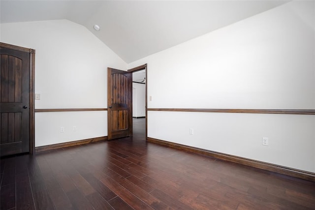 unfurnished room with wood finished floors, baseboards, and vaulted ceiling