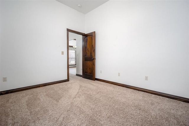 spare room featuring baseboards and carpet floors