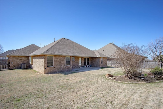 back of house with central air condition unit, a patio, a fenced backyard, a yard, and brick siding