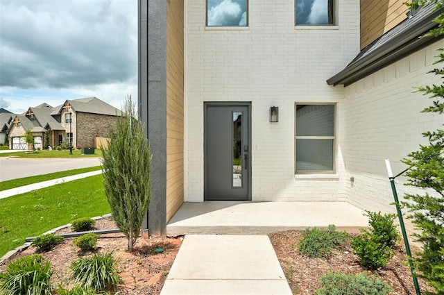 8101 Jenny Ln, Edmond, OK 73034 - property entrance with brick siding, a residential view, and a lawn