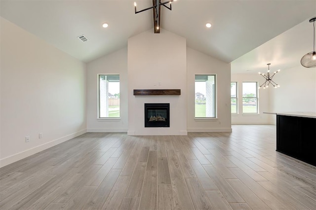 8101 Jenny Ln, Edmond, OK 73034 - unfurnished living room featuring a chandelier, beam ceiling, light wood-type flooring, a glass covered fireplace, and baseboards