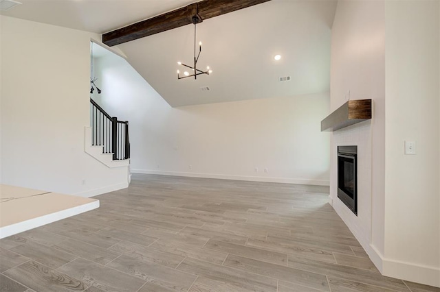8101 Jenny Ln, Edmond, OK 73034 - unfurnished living room featuring a chandelier, stairs, light wood-style flooring, baseboards, and a glass covered fireplace