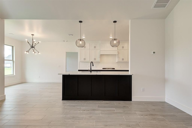 8101 Jenny Ln, Edmond, OK 73034 - kitchen with light countertops, wood finish floors, a chandelier, and white cabinetry