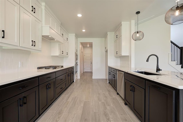 8101 Jenny Ln, Edmond, OK 73034 - kitchen with a sink, white cabinets, stainless steel appliances, light stone countertops, and a peninsula